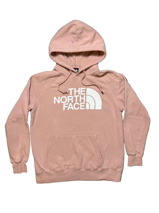 Pink hoodie with The North Face logo on a textured surface